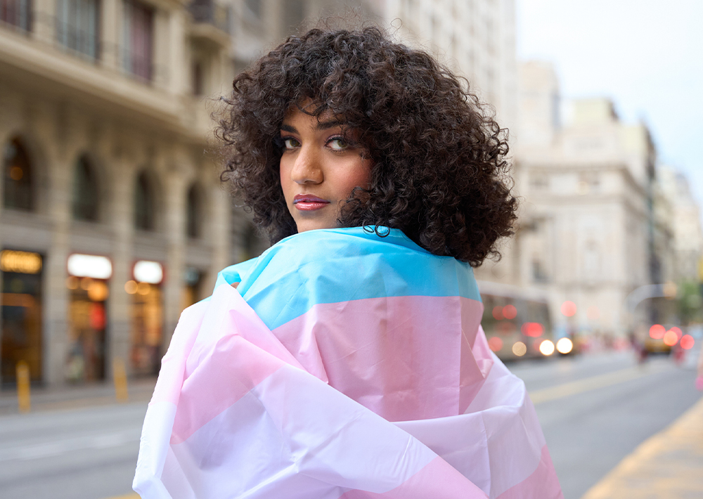 Individual looking backward, draped in pink and blue shawl