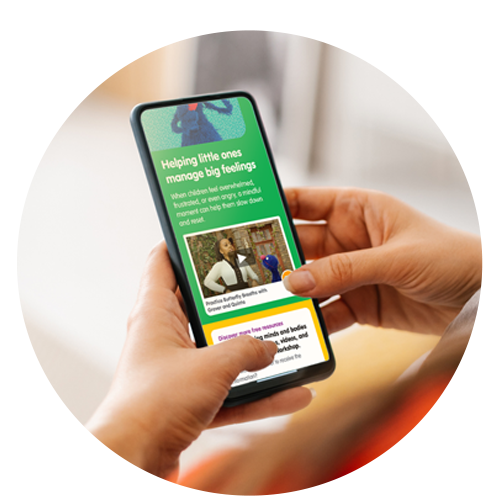 Hands holding an iPhone with the Sesame Street campaign visible on the screen